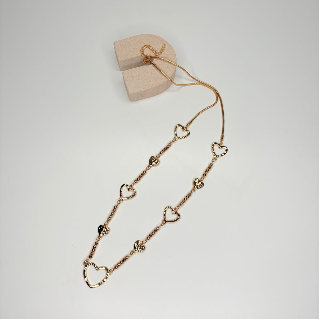 Long gold necklace, with battered metal heart stations