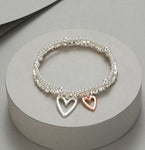 Elasticated bracelet in silver & gold, with two-row heart pendant
