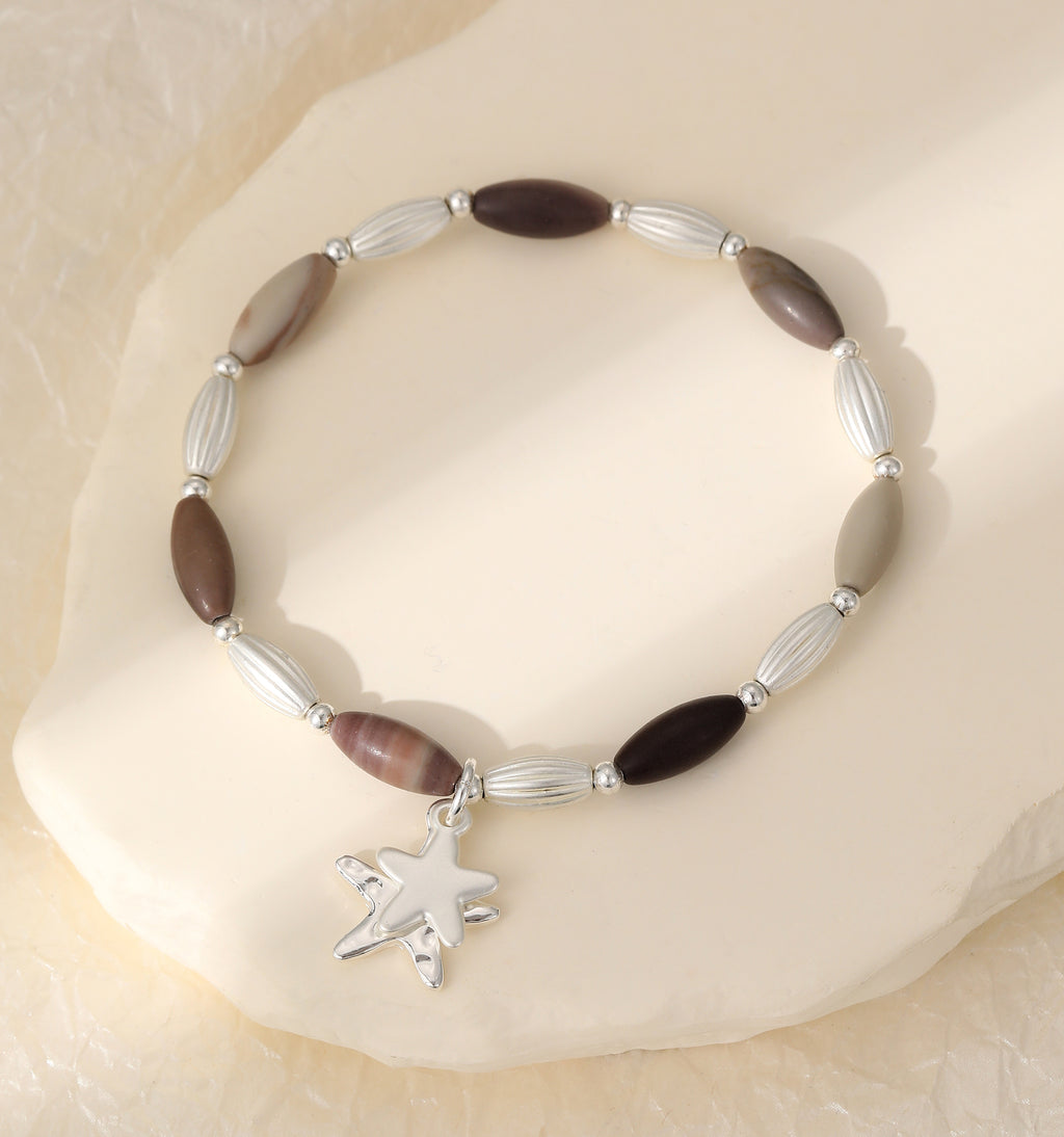 Elasticated bracelet in silver & earthy tones, with star pendant