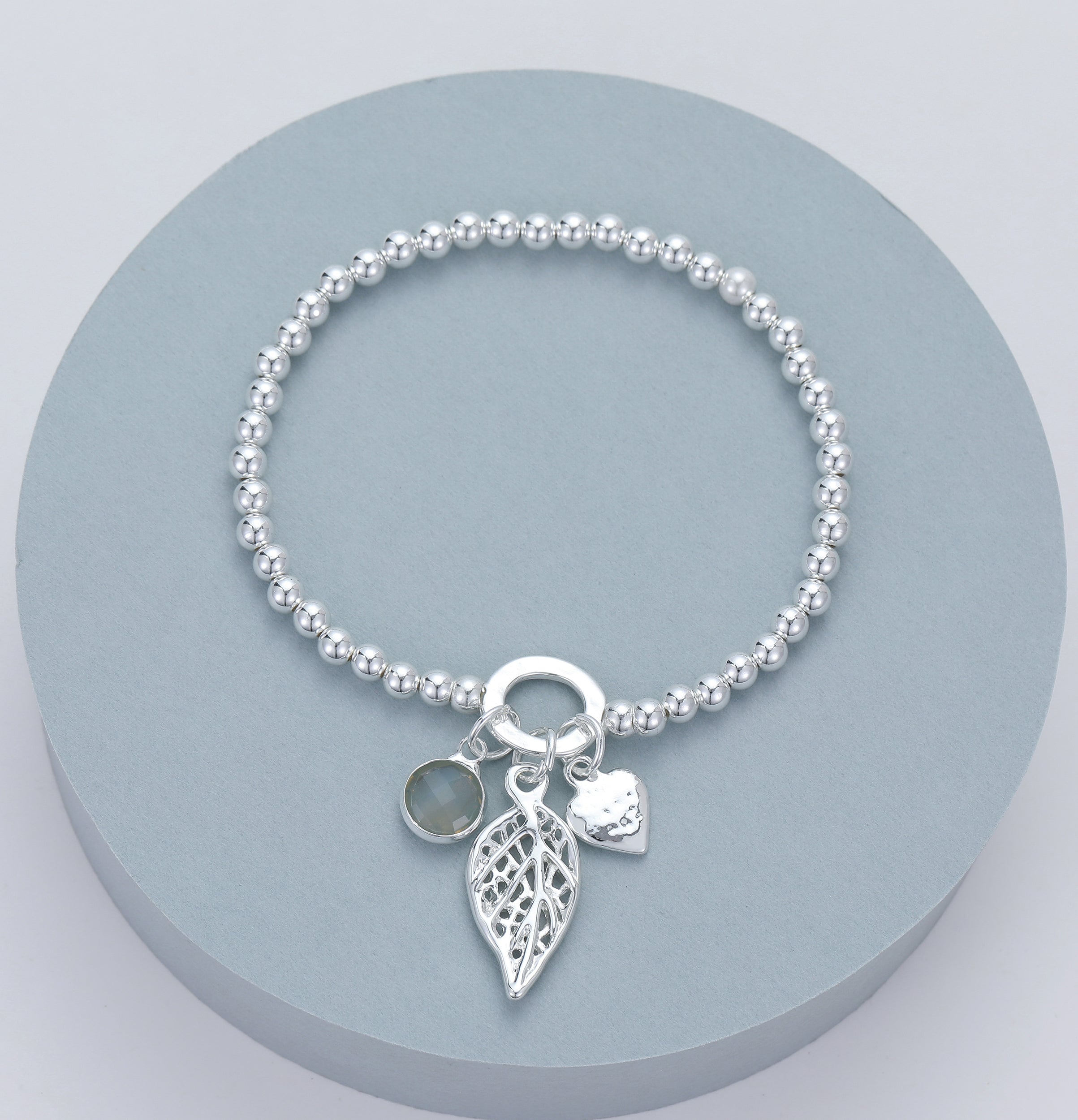 Elasticated bracelet with silver beads and heart, leaf and crystal pendant