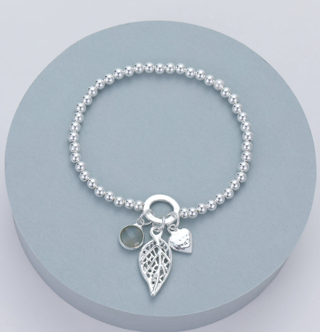 Elasticated bracelet with silver beads and heart, leaf and crystal pendant
