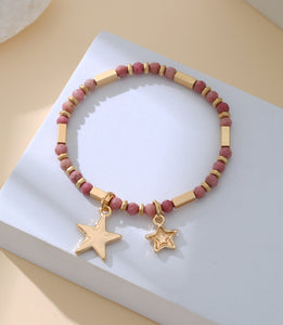 Elasticated bracelet in gold, with pink beads and star pendant