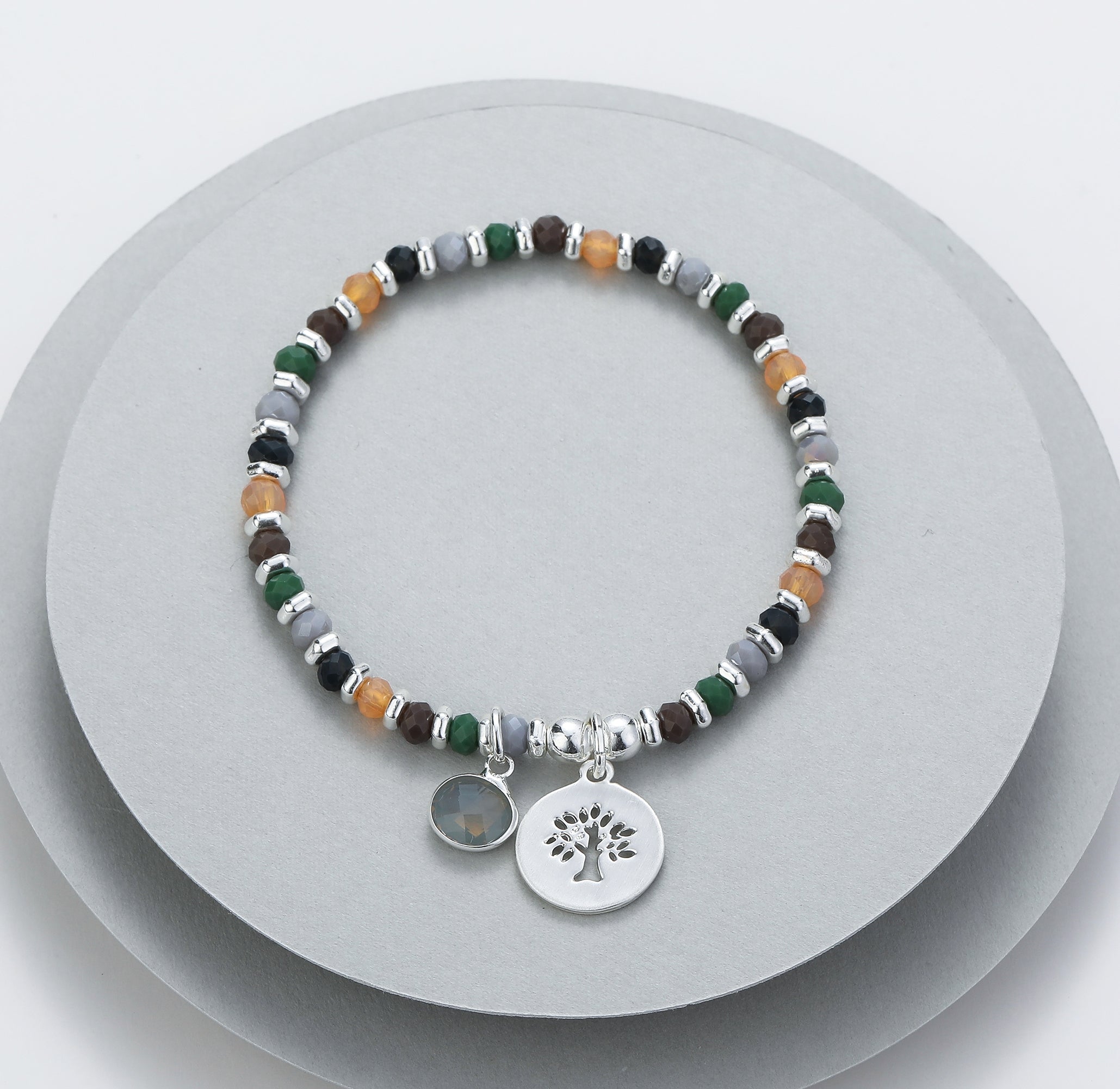 Elasticated bracelet in silver, green & earthy tones, with tree pendant