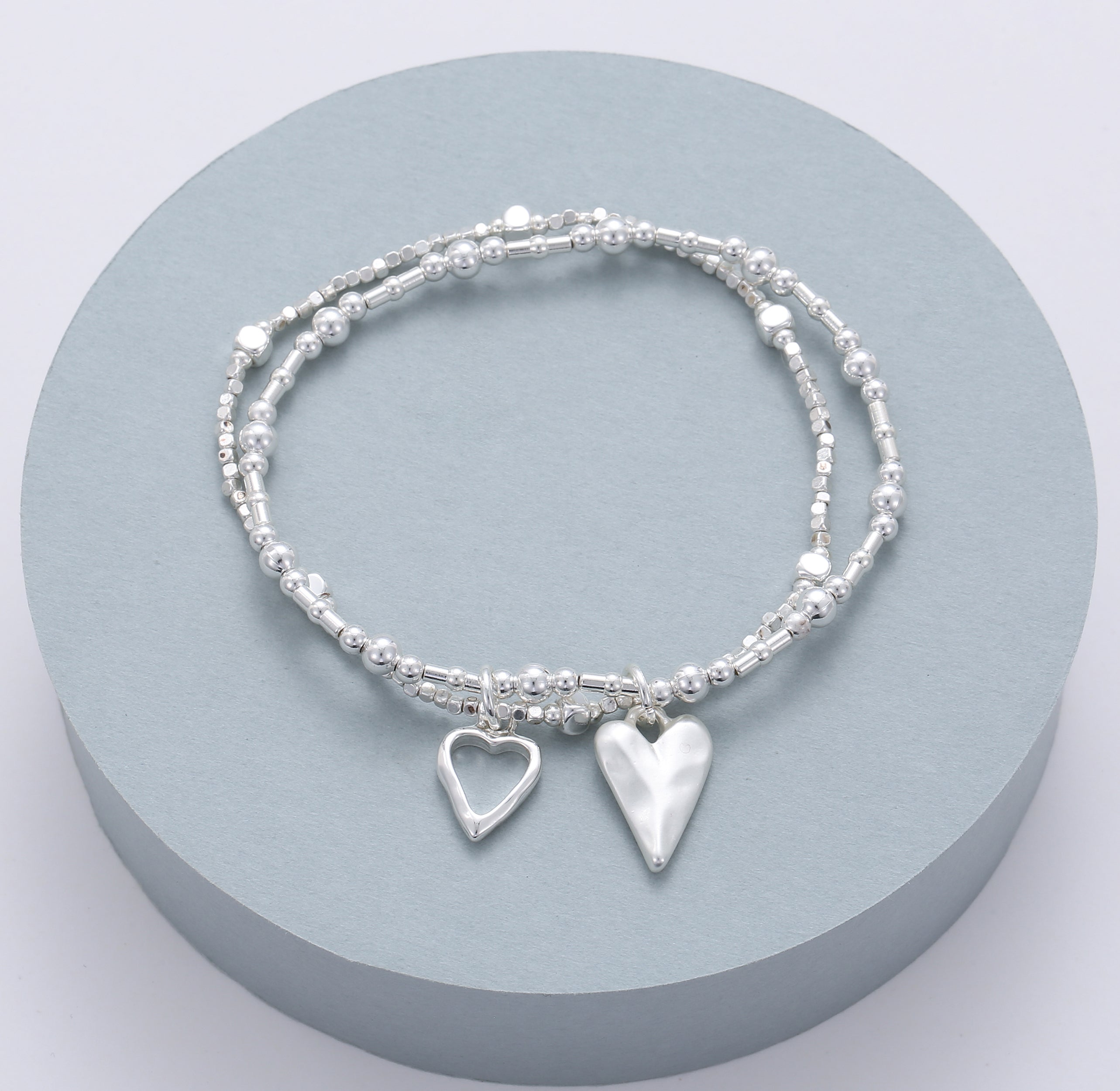 Elasticated bracelet in silver, with two-row open & solid heart pendant