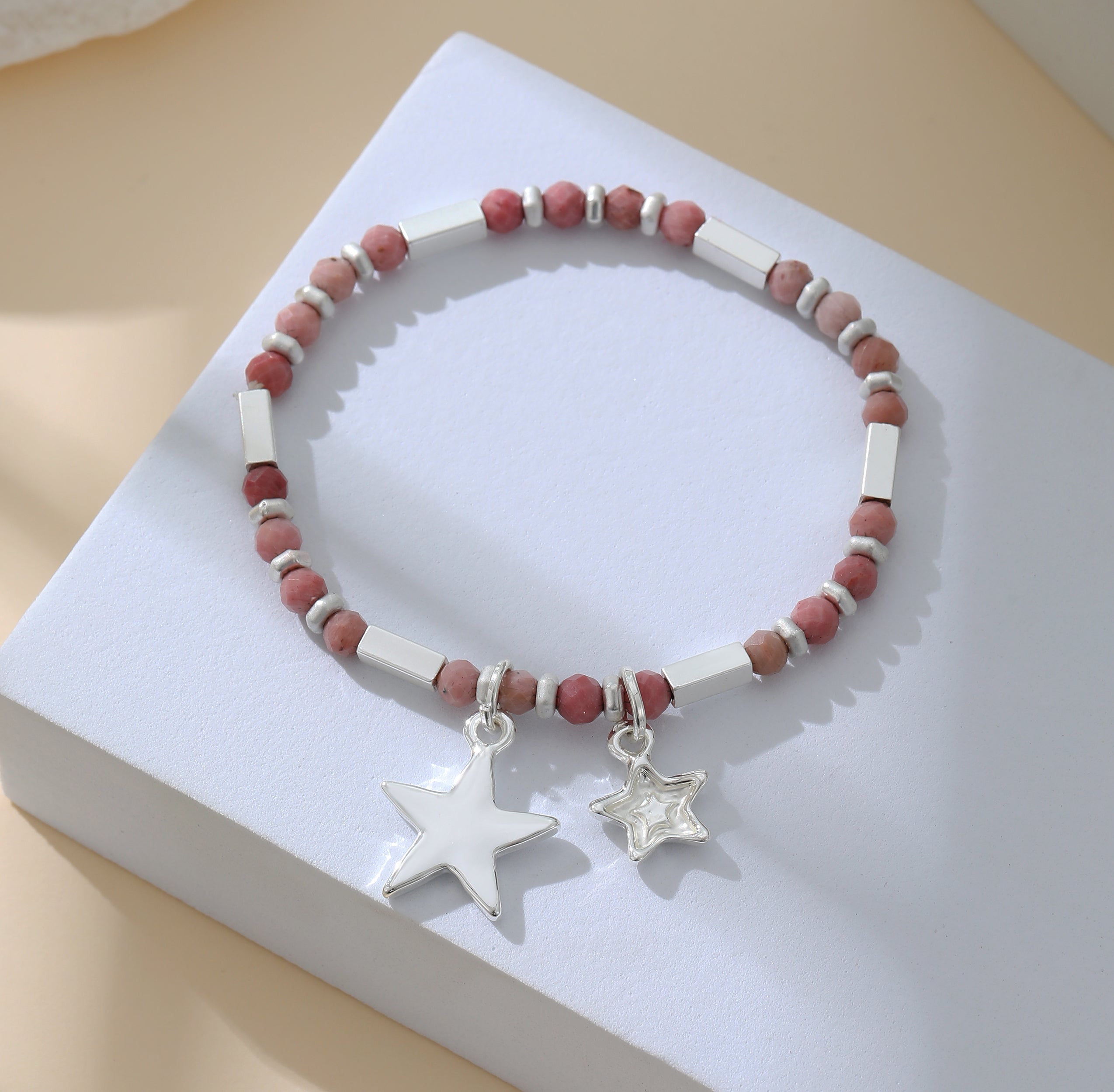 Elasticated bracelet in silver, with pink beads and star pendant