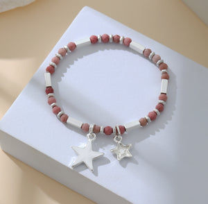 Elasticated bracelet in silver, with pink beads and star pendant