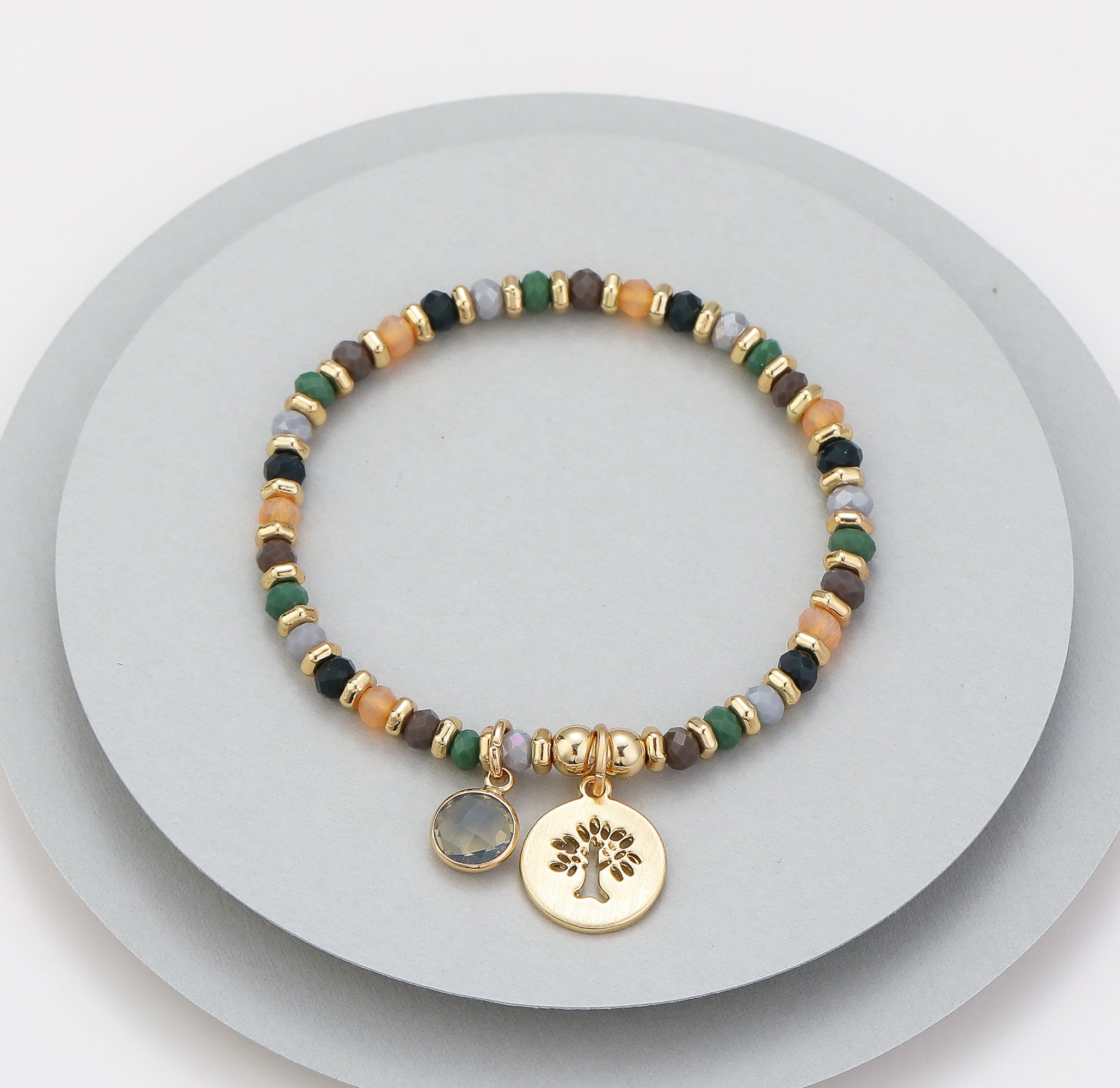 Elasticated bracelet in gold, green & earthy tones, with tree pendant