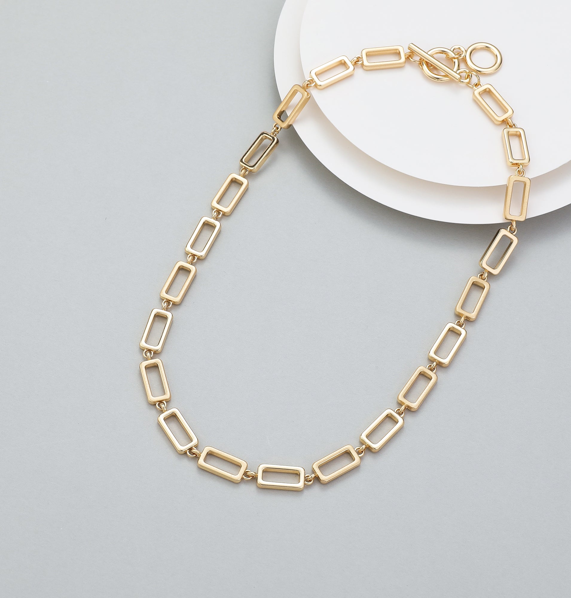 Short t-bar fastener necklace in gold, with rectangular stations