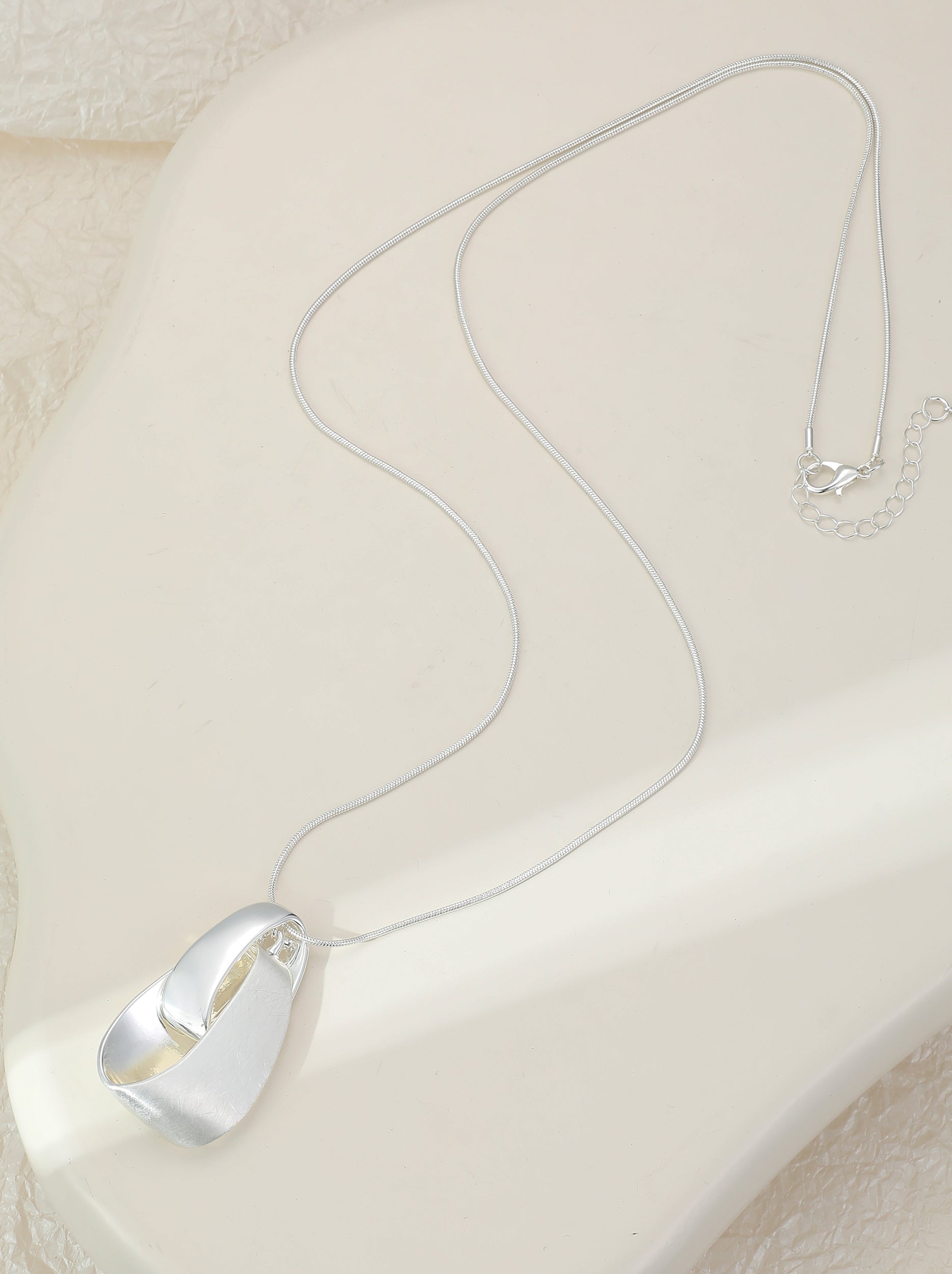 Long silver necklace, with knot design pendant