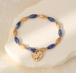 Elasticated bracelet in gold & blue tones, with heart pendant