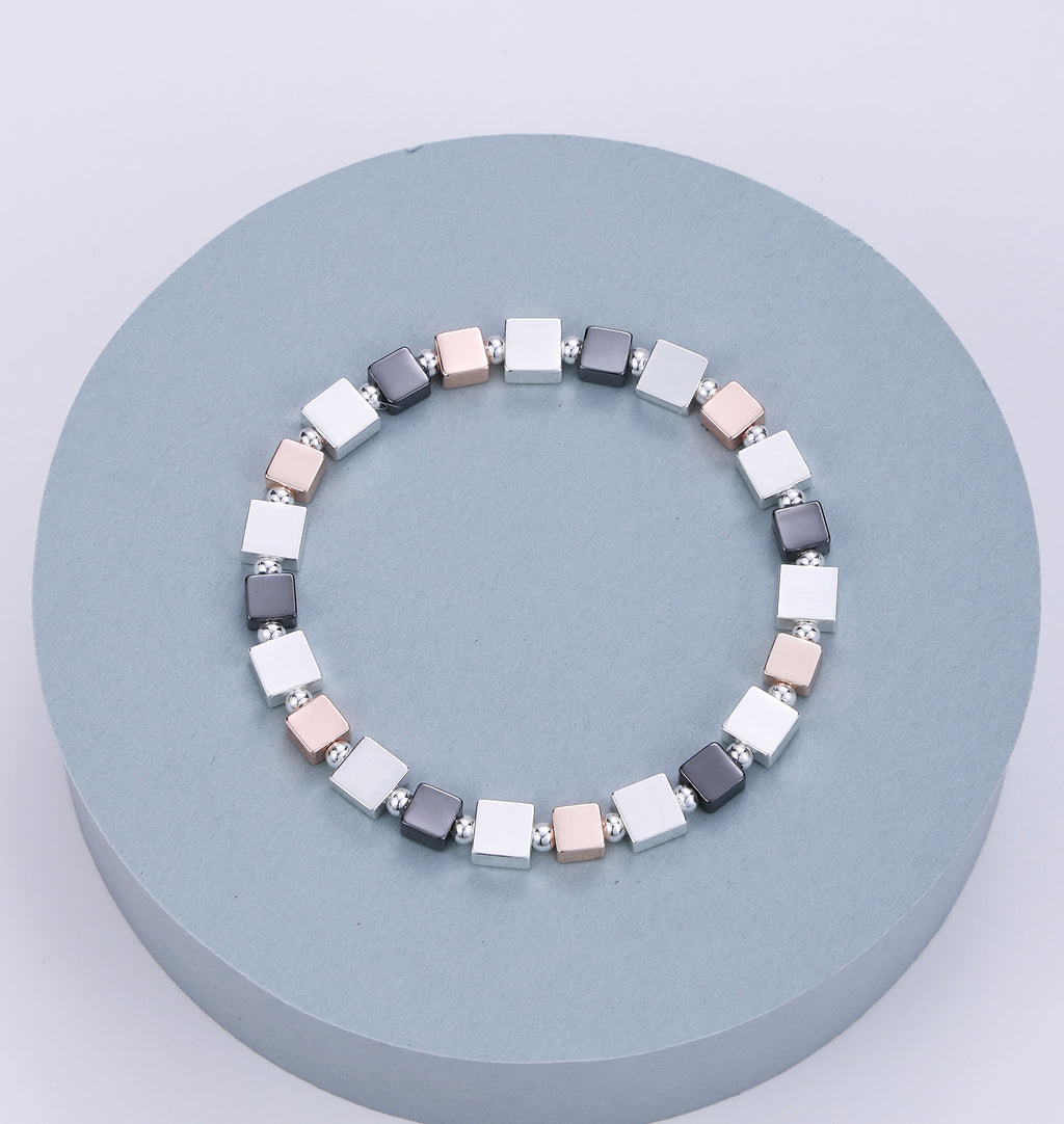 Elasticated bracelet in silver, pewter and gold with square stations