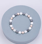 Elasticated bracelet in silver, pewter and gold with square stations