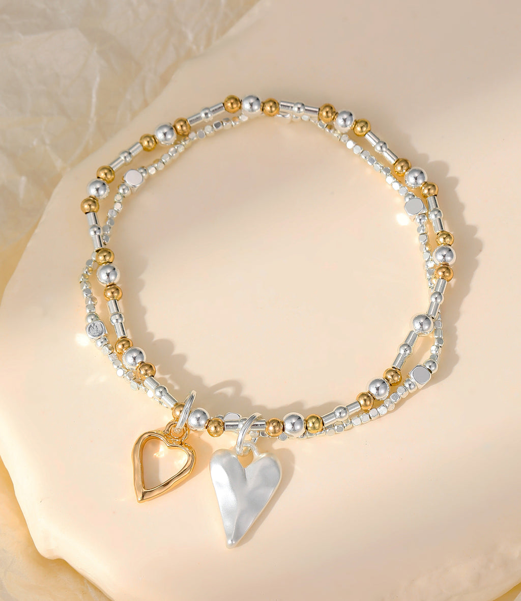 Elasticated bracelet in silver & gold, with two-row open & solid heart pendant