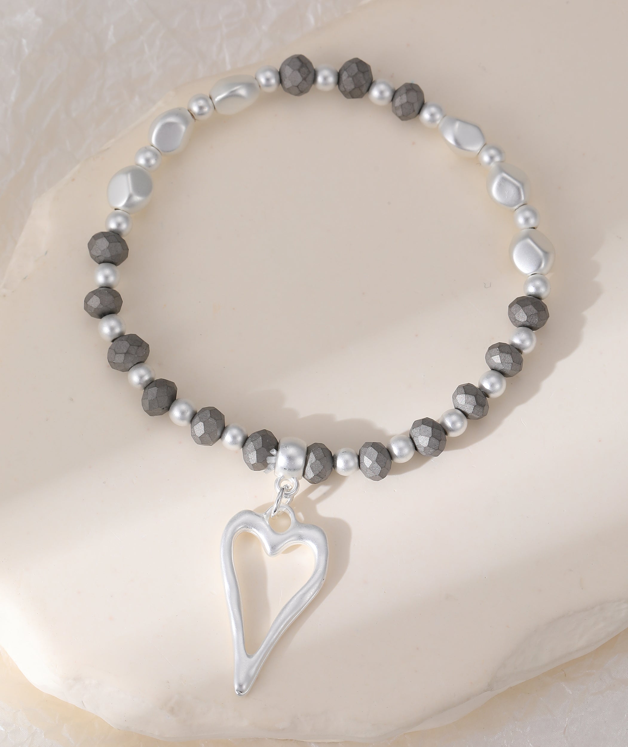 Elasticated bracelet in matte silver with heart pendant