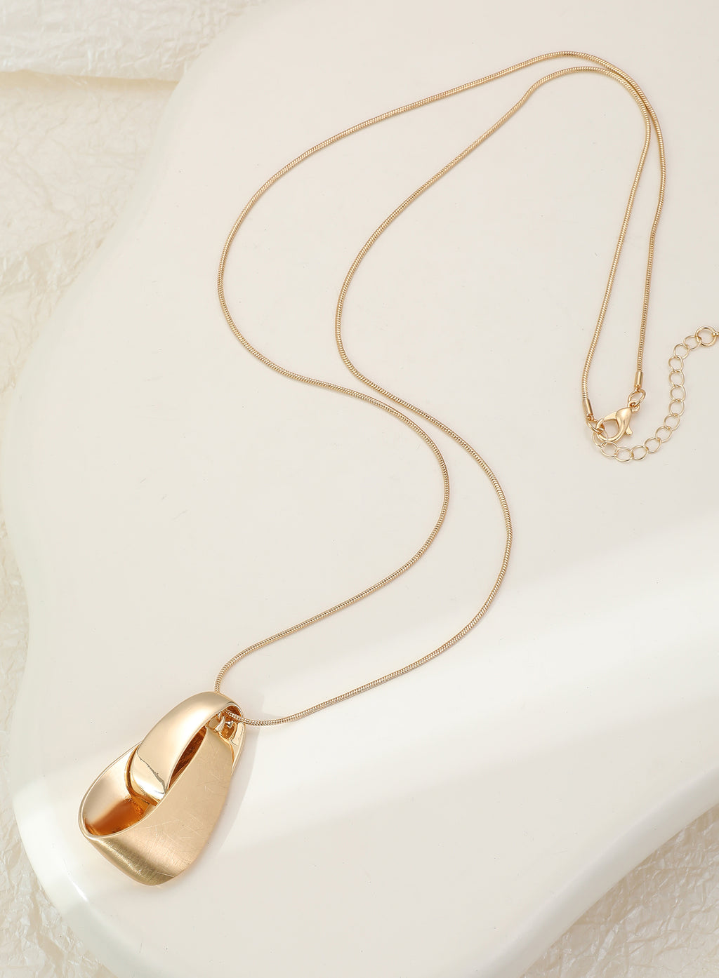 Long gold necklace, with knot design pendant