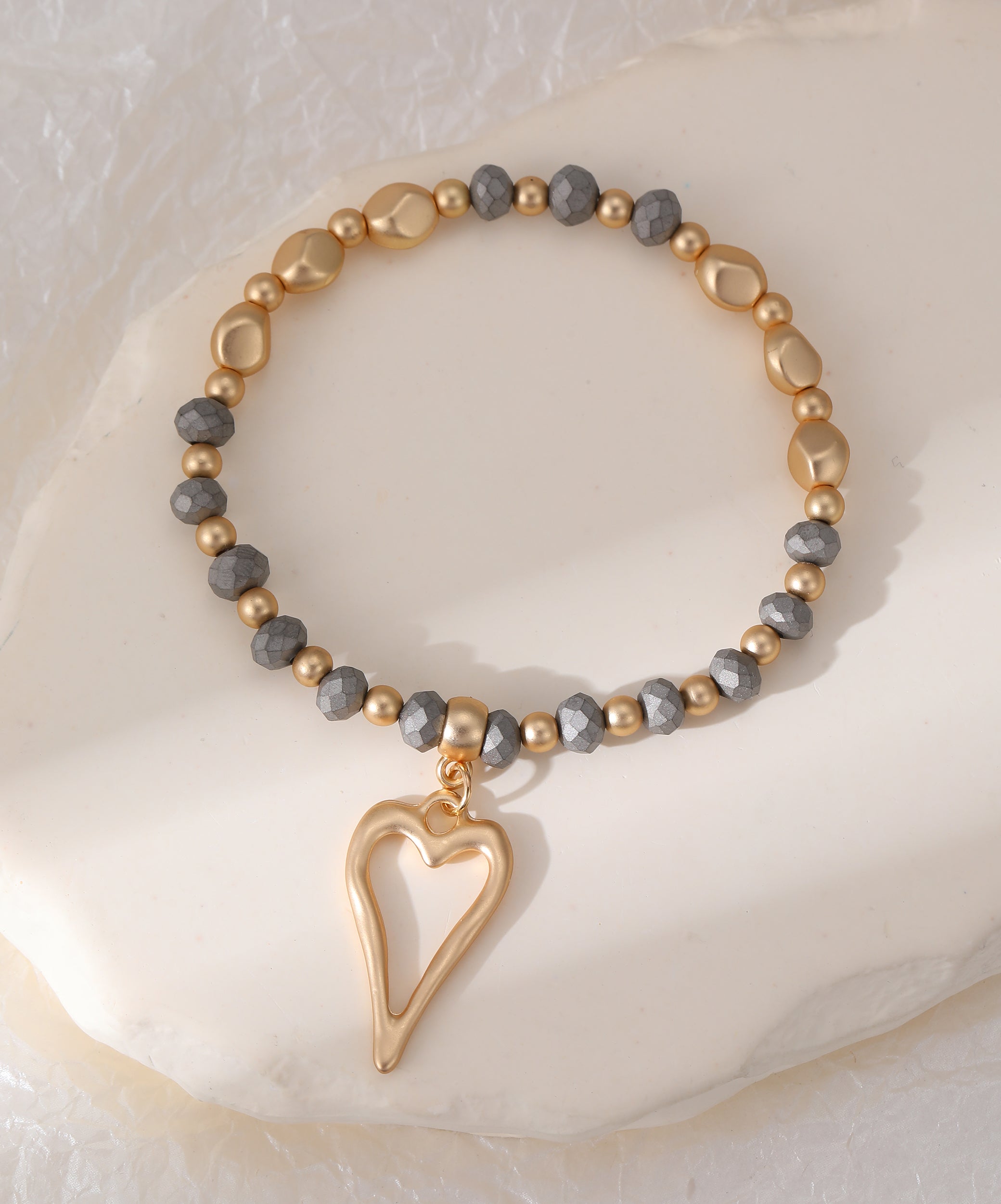 Elasticated bracelet in matte gold with heart pendant