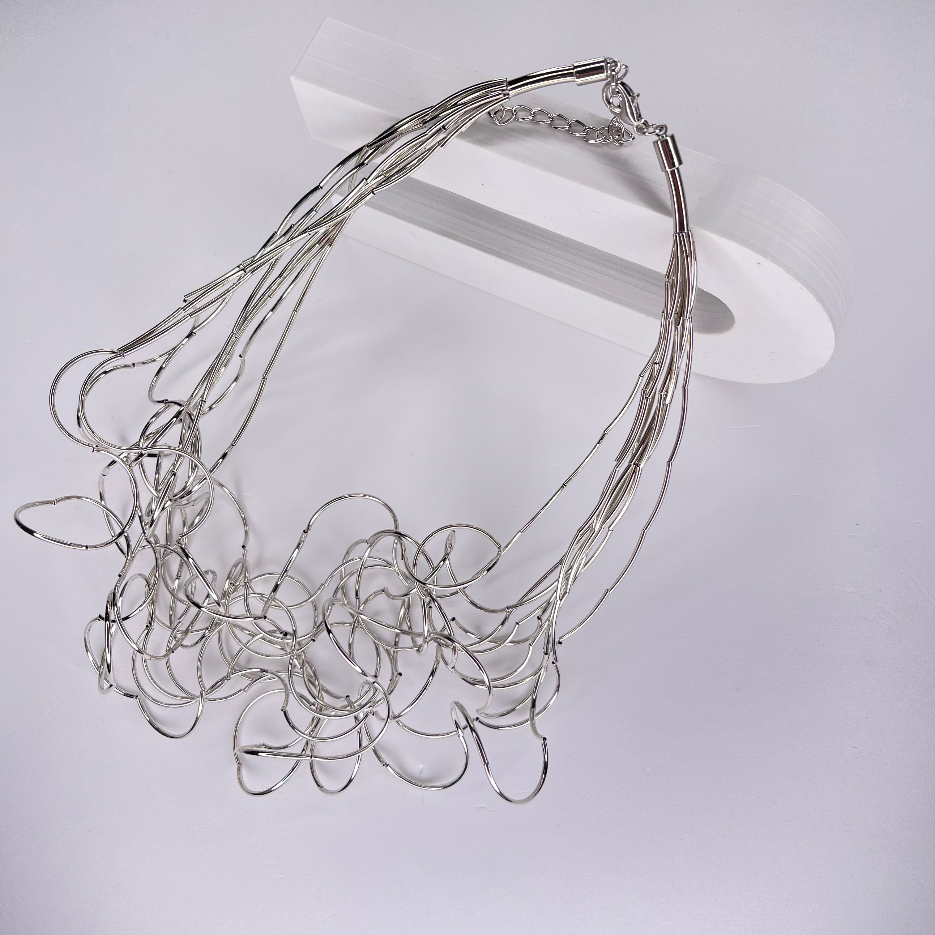 Short necklace, with ‘spaghetti’ type twists in silver, with extension chain